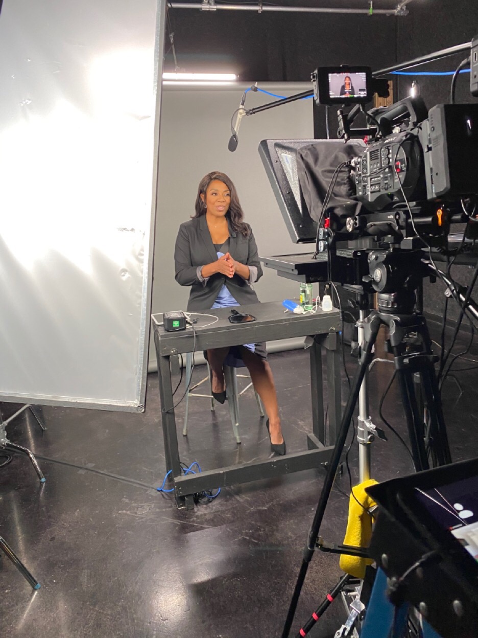 Wendee on camera in a broadcast studio
